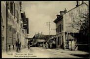 ouvrir dans la visionneuse : Légende inscrite sur la carte postale : 10463 - Divonne-les-Bains. - Rue principale et postes
