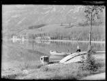 Petit garçon appuyé sur une barque retournée sur les rives du lac de Nantua